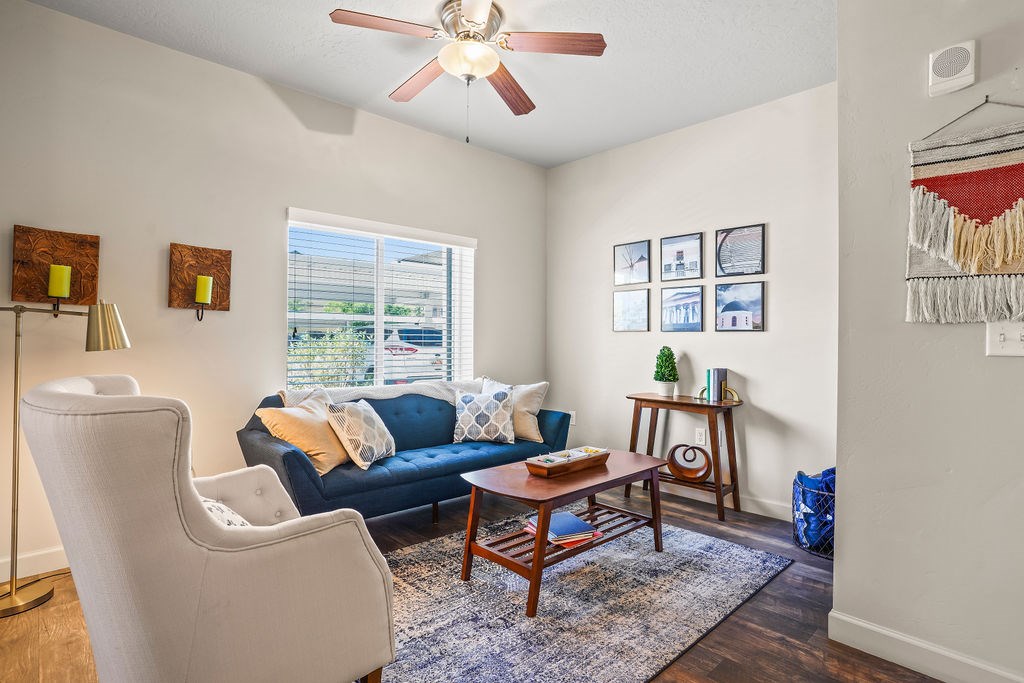 A living room with a blue couch and a white chair.