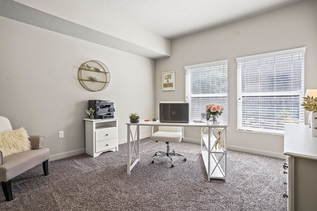 A room with a desk, a couch, and a chair.