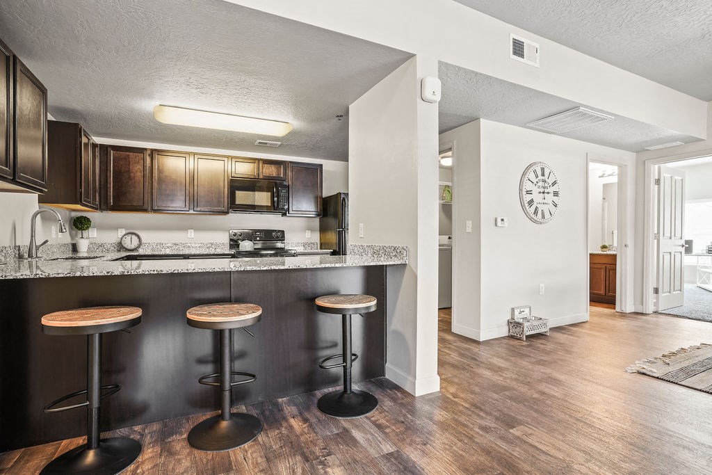 a kitchen with a bar with three stools