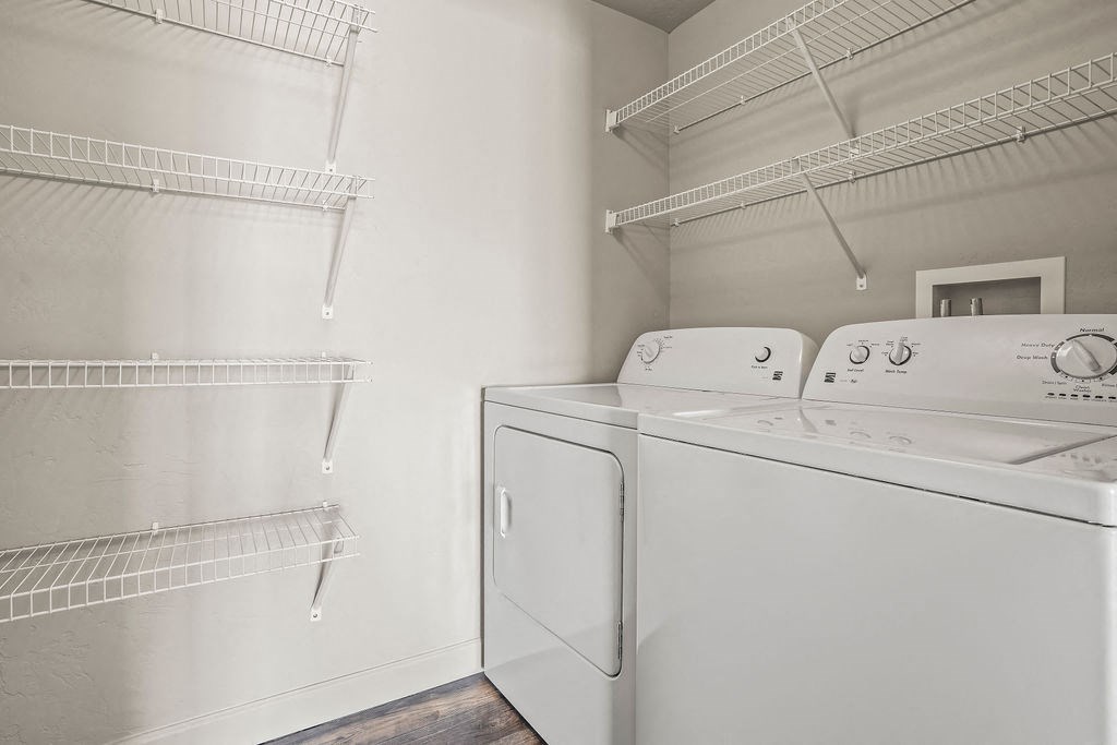 a laundry room with a washer and dryer and a closet with shelves