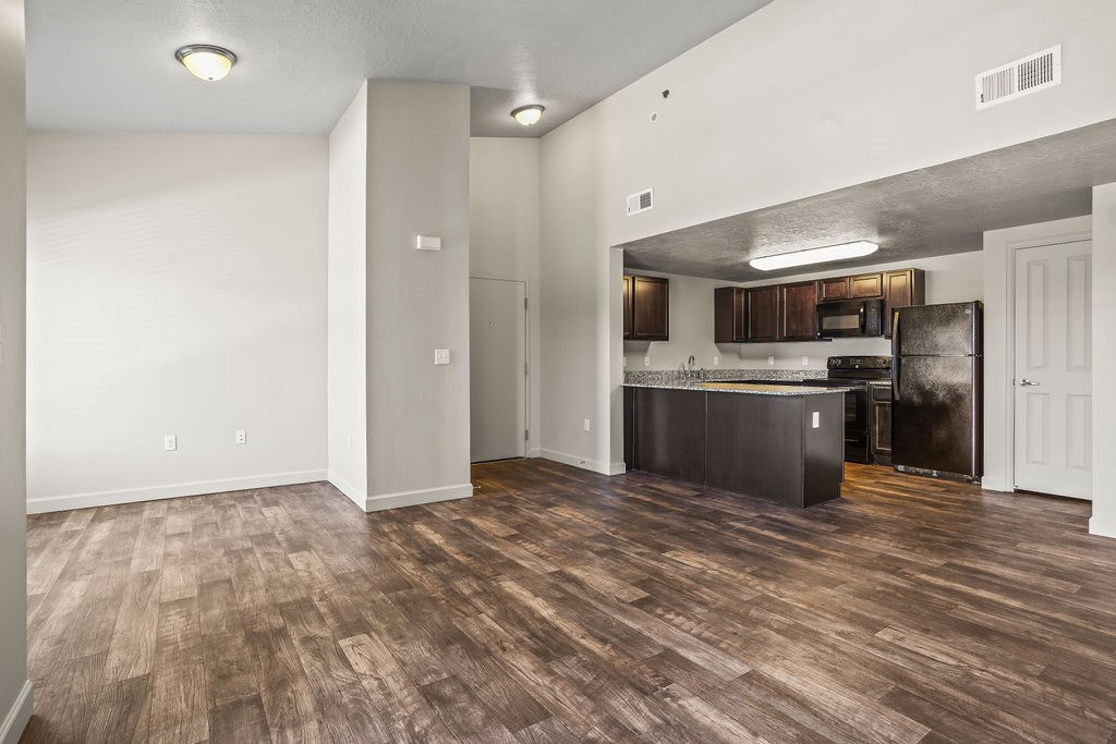 A kitchen with a refrigerator, oven, and microwave.