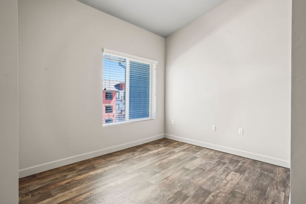 A room with a window and wooden flooring.