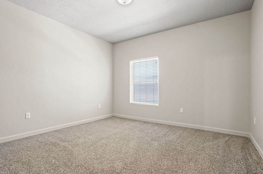 an empty room with carpet and a window
