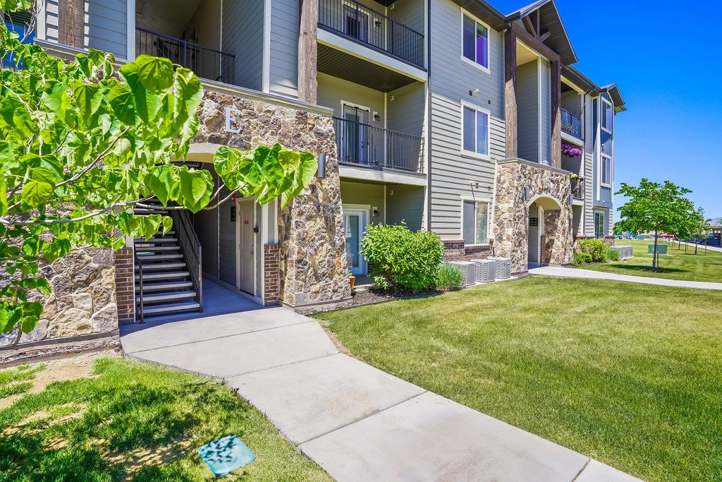 A stone building with a balcony and a green lawn in front.