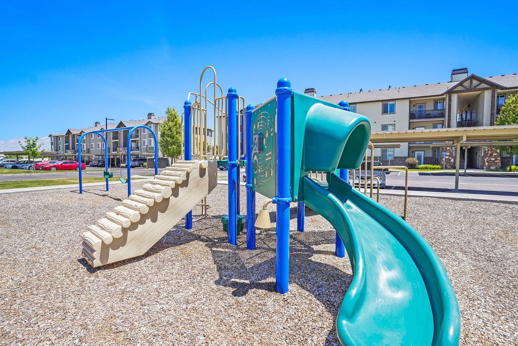 A playground with a blue and green slide.