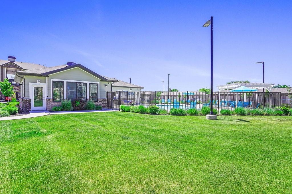 A house with a green lawn in front of it.