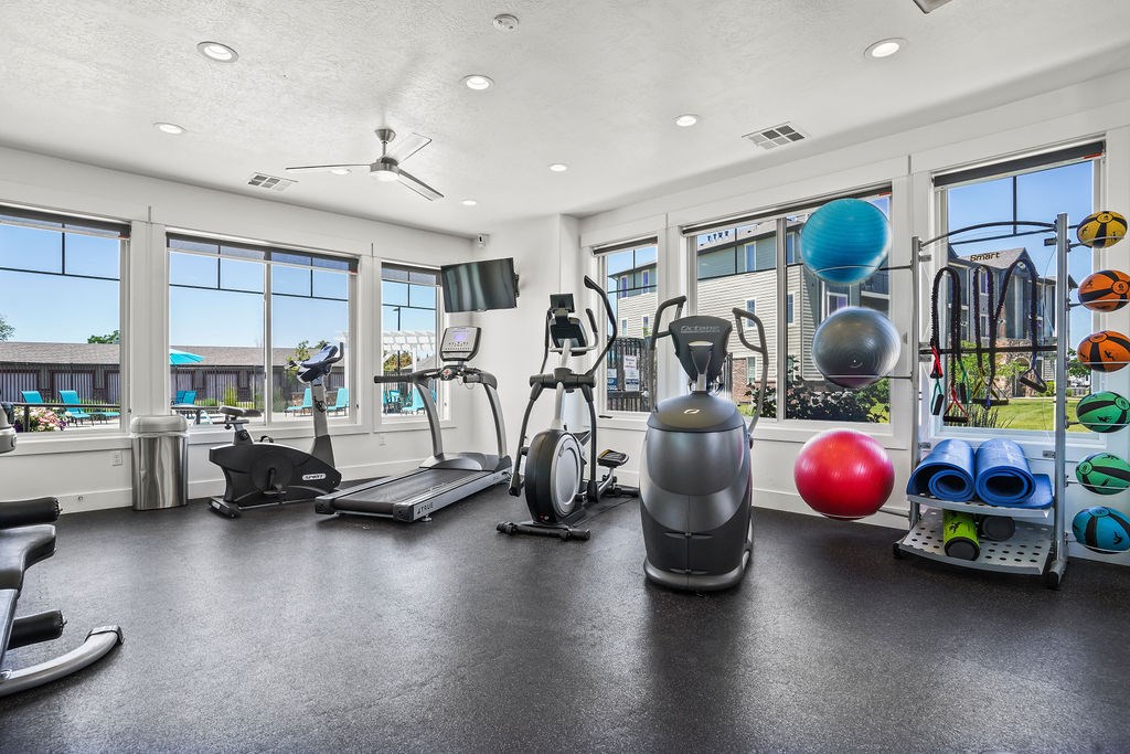 A gym with a variety of equipment including a treadmill, exercise bike, and weights.