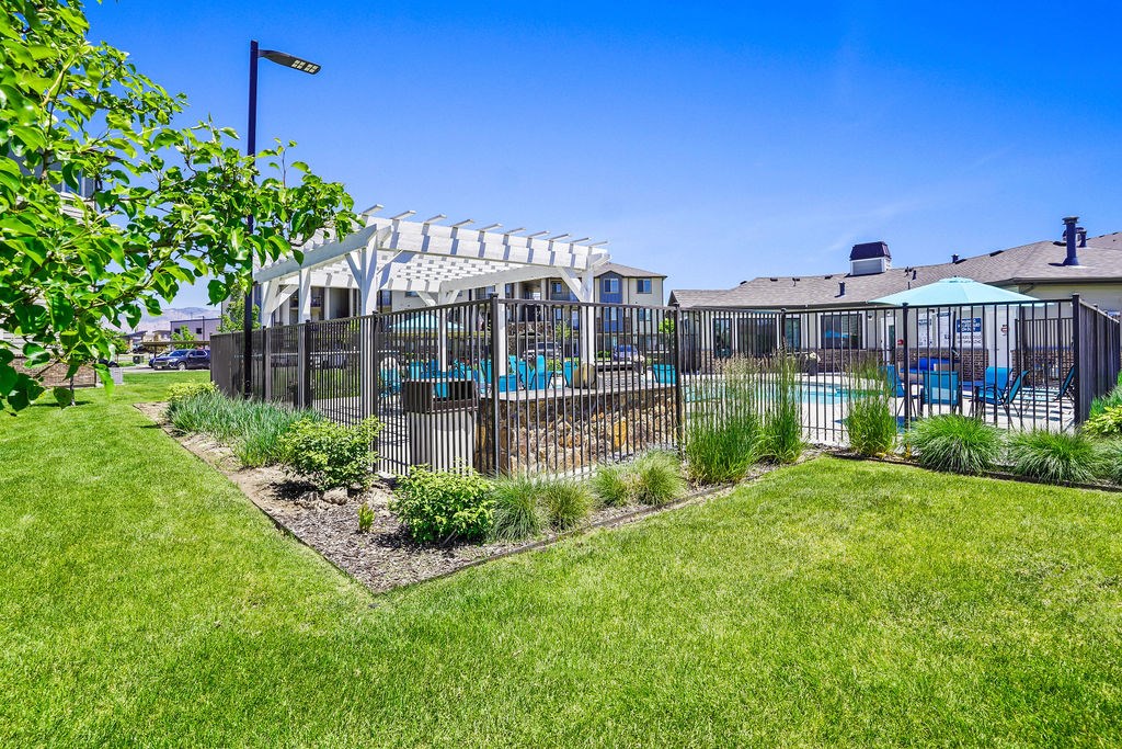 A backyard with a pool and a fence.