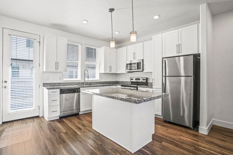 a kitchen with an island and a stainless steel refrigerator