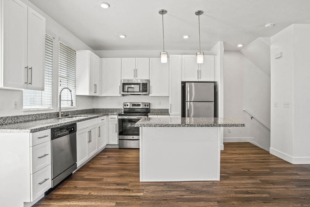 a kitchen with white cabinets and a counter top at Aero Luxury Townhomes in Layton, Utah