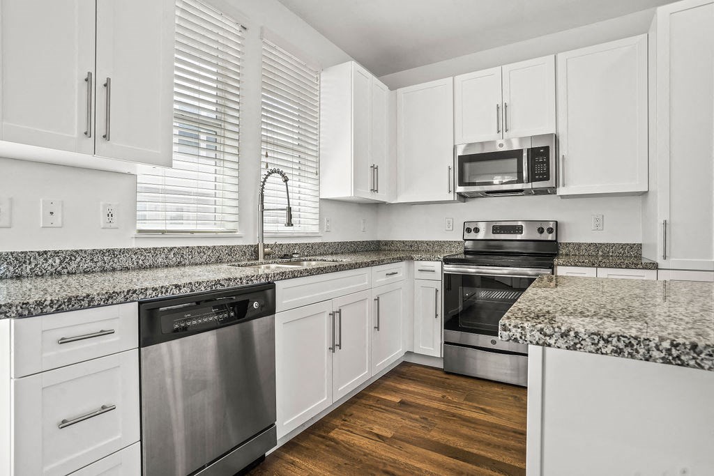 a kitchen with granite counter tops and stainless steel appliances at Aero Luxury Townhomes in Layton, Utah