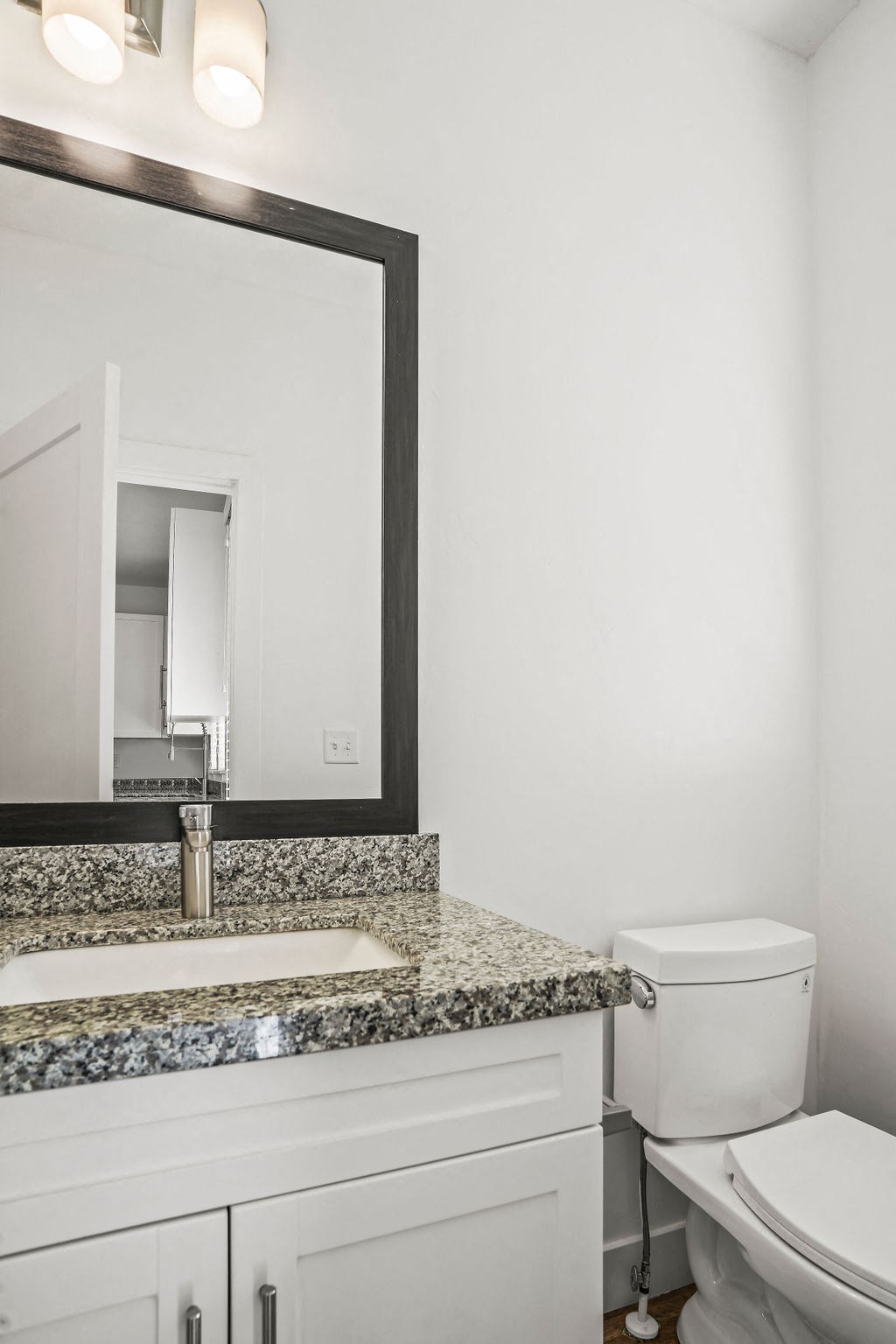 a bathroom with a sink and a toilet and a mirror  at Aero Luxury Townhomes in Layton, Utah