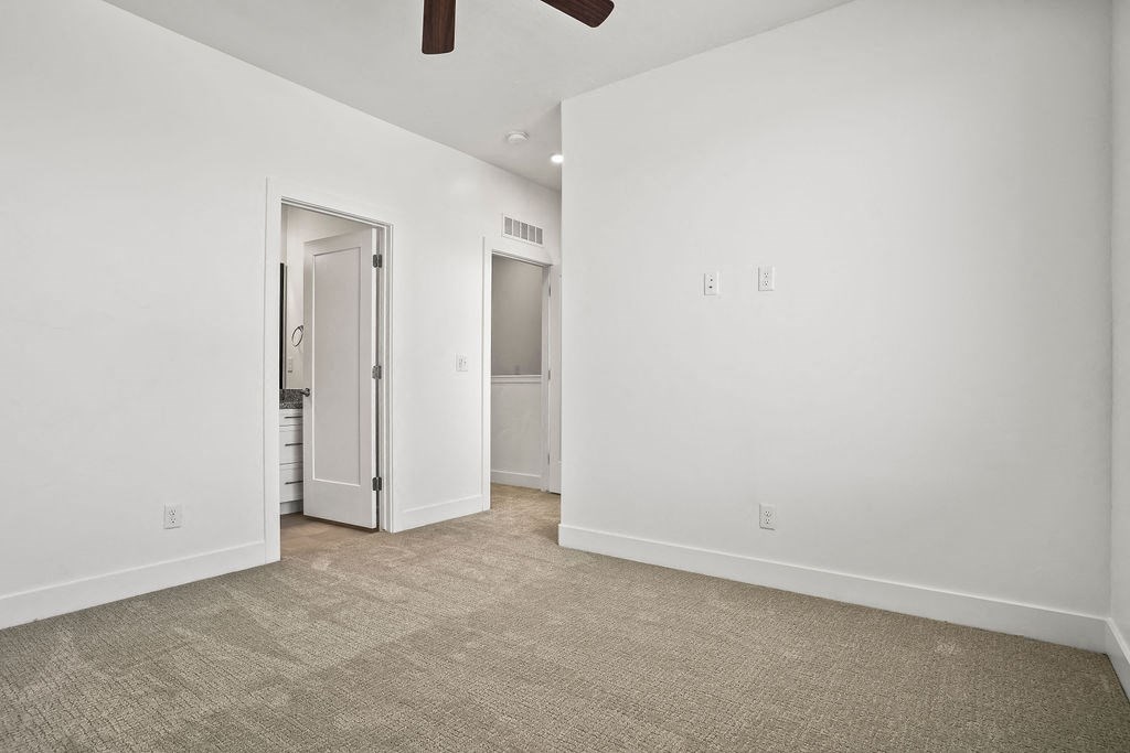 a living room with white walls and a door to a bathroom  at Aero Luxury Townhomes in Layton, Utah