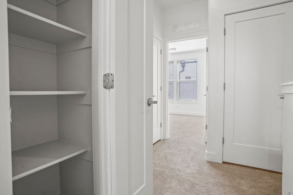 a walk in closet with shelves and a door to a bedroom  at Aero Luxury Townhomes in Layton, Utah