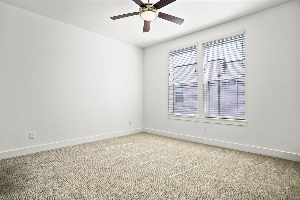 an empty room with a ceiling fan and a window  at Aero Luxury Townhomes in Layton, Utah