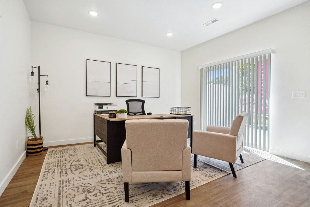 an office with two chairs and a desk and a window