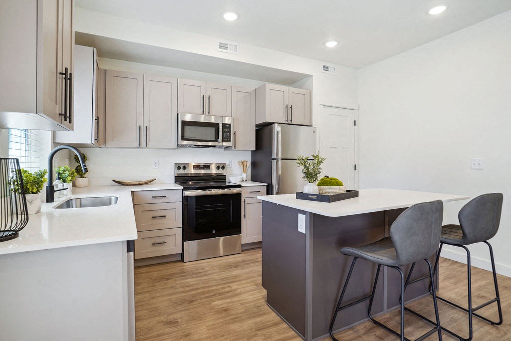 an open kitchen with an island with two stools