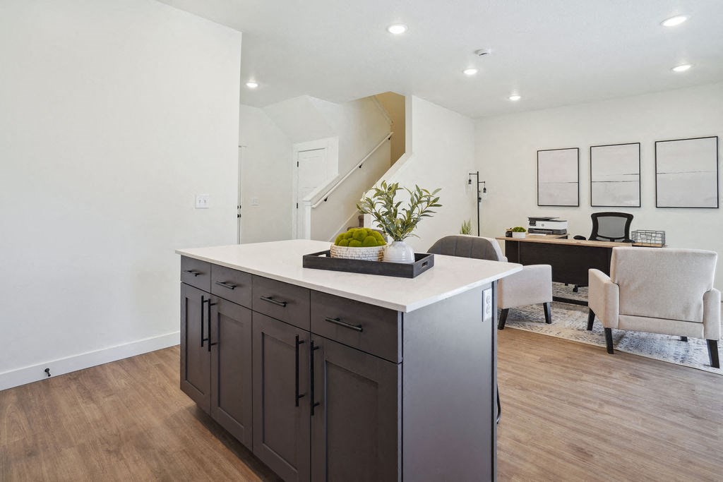 a kitchen with an island and a living room with a desk