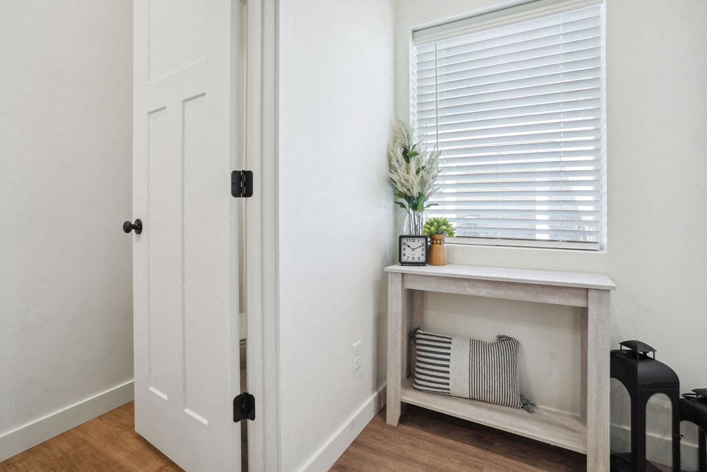 a hallway with a window and a table with a plant on it