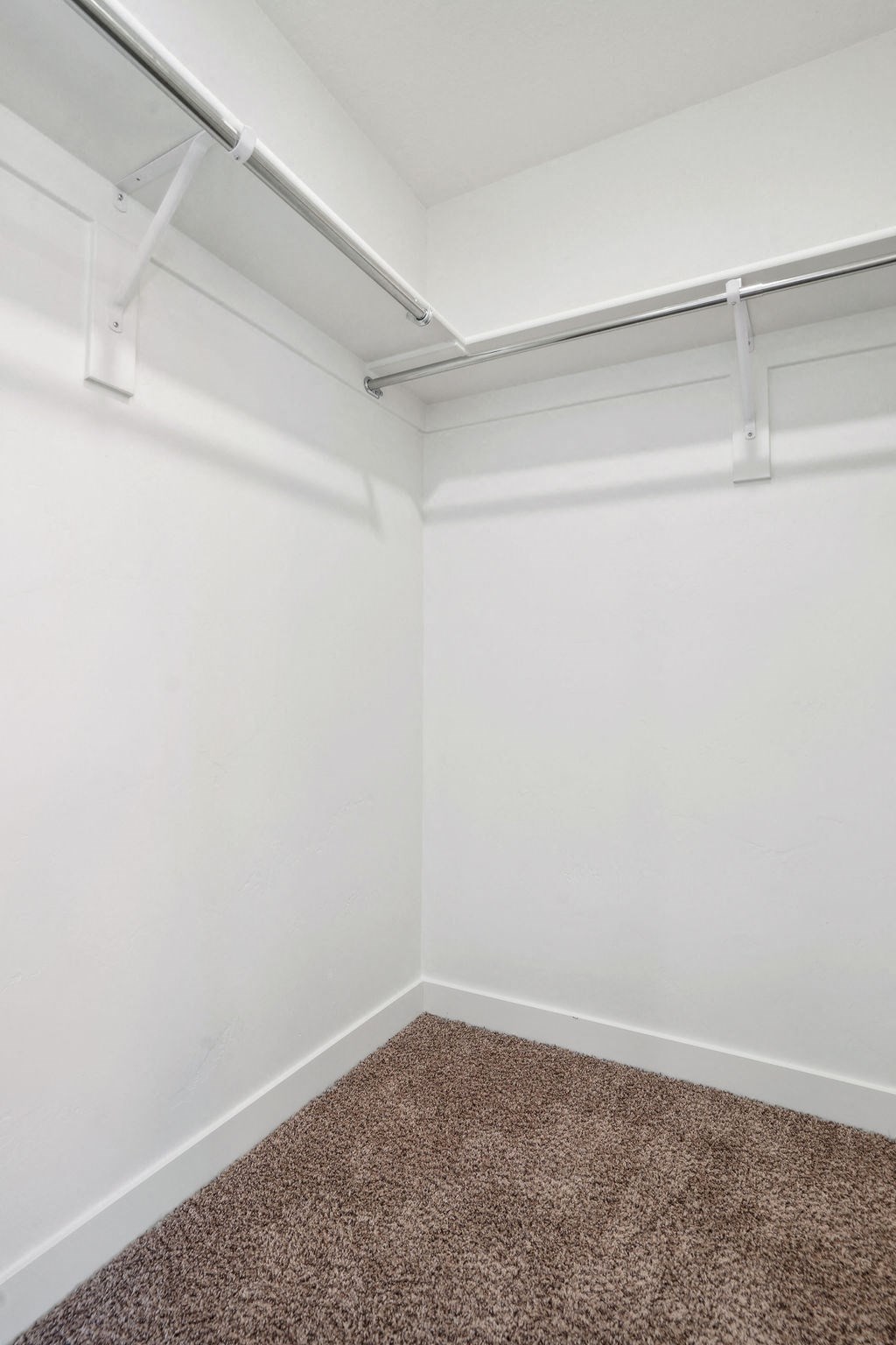 an empty room with white walls and a carpet