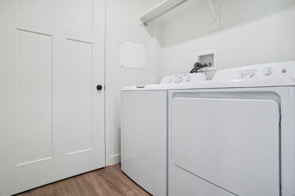 a laundry room with a washer and dryer and white cabinets
