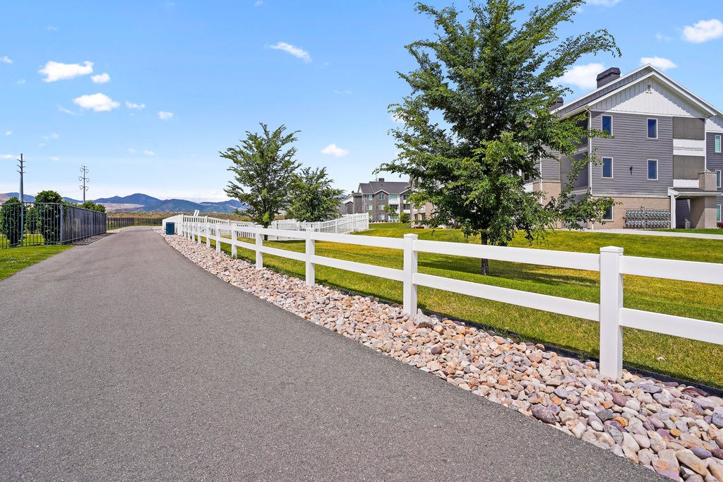 Affinity 56 Apartments for rent in West Jordan, UT  A white fence runs along a paved road.