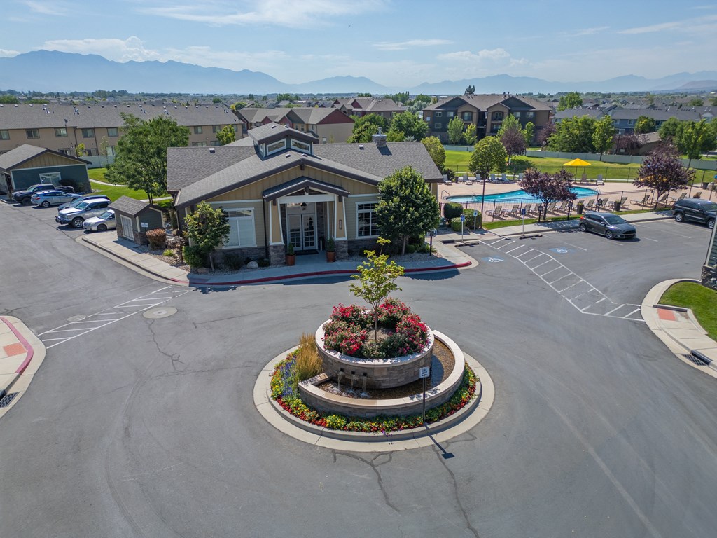 a fountain in the middle of a parking lot in front of a building at Aldara Apartments in Saratoga Springs, Utah