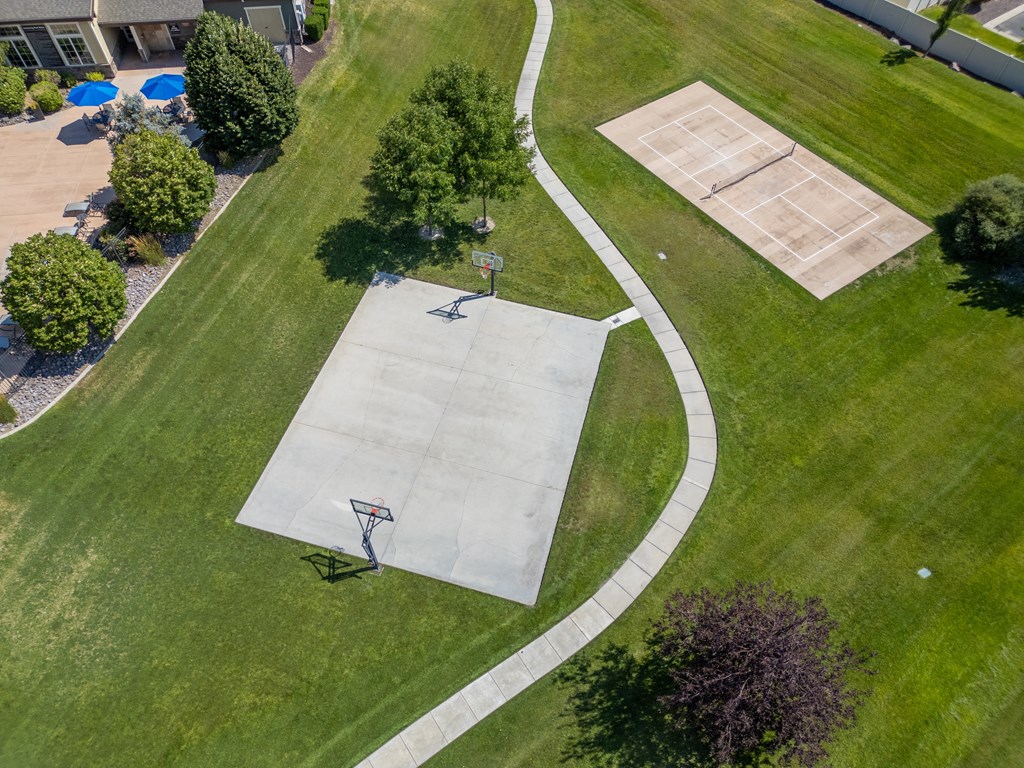 two people playing basketball on a court in a park at Aldara Apartments in Saratoga Springs, Utah