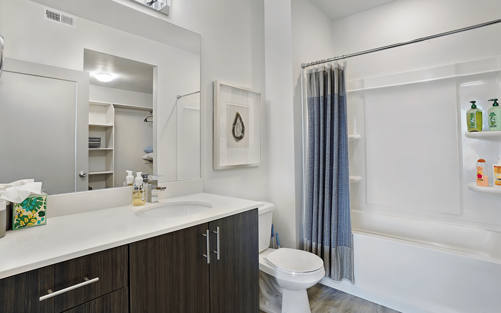 A white bathroom with a toilet, sink, and a shower curtain.