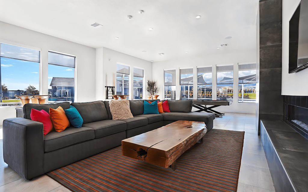 A modern living room with a grey couch and a wooden coffee table.