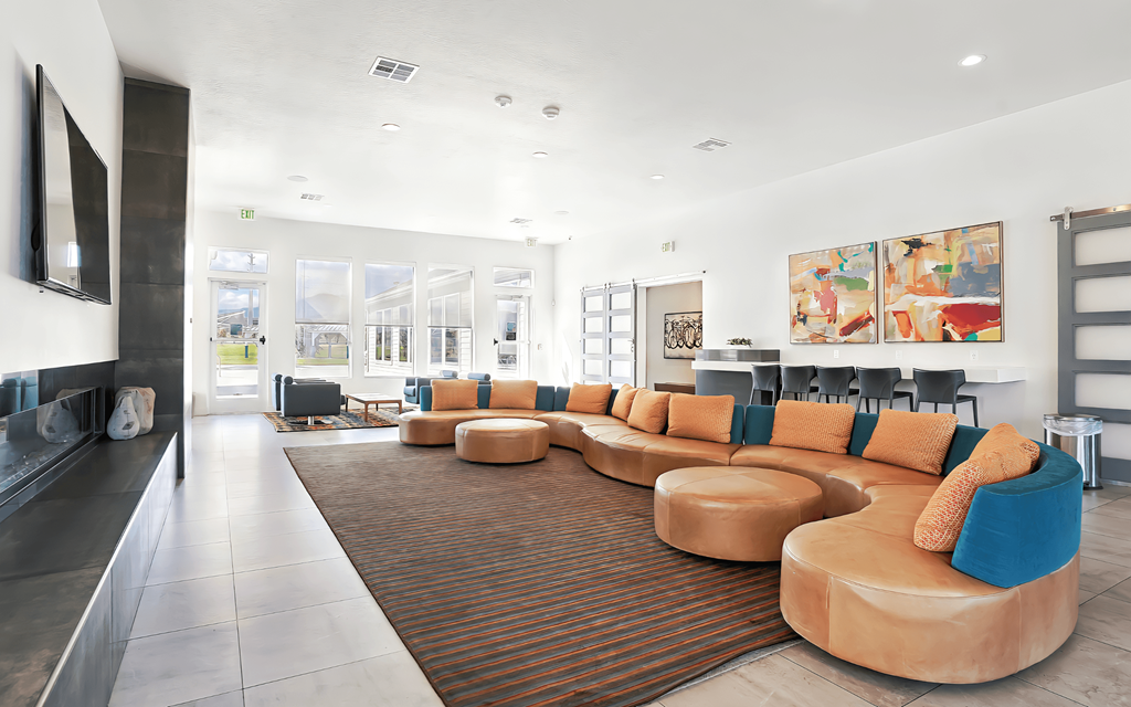 A modern living room with a long sofa and a fireplace.