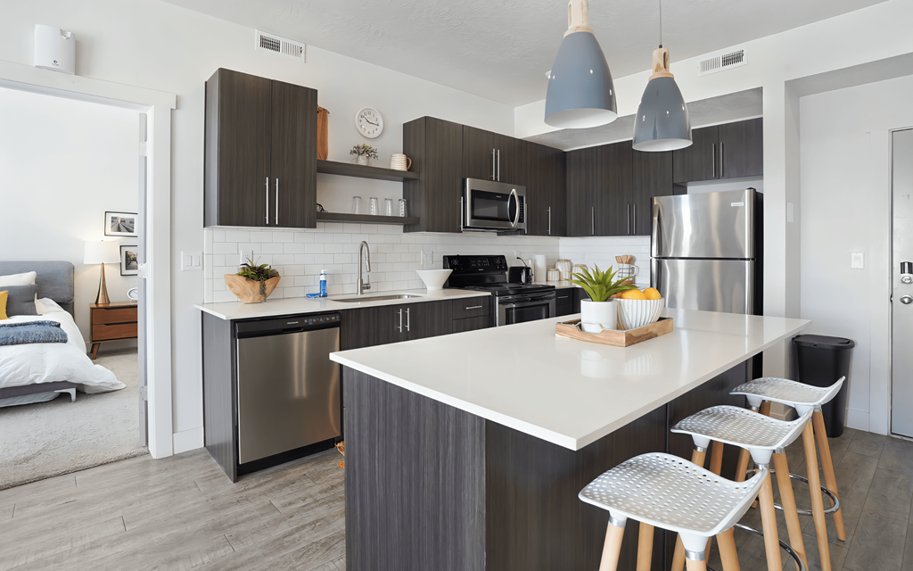 A modern kitchen with a white island and stainless steel appliances.