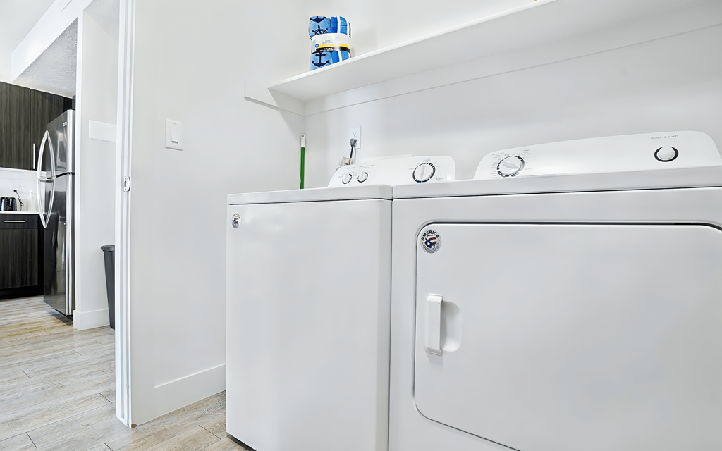 A white washing machine and dryer in a laundry room.