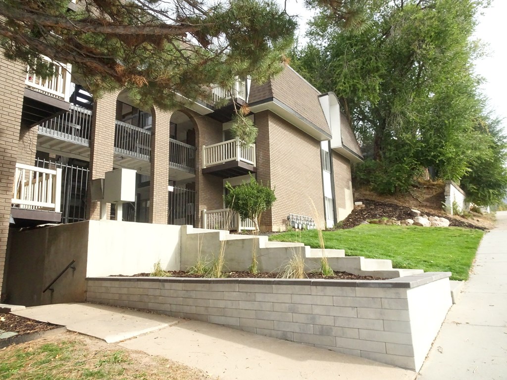A building with a balcony and a wall in front of it.