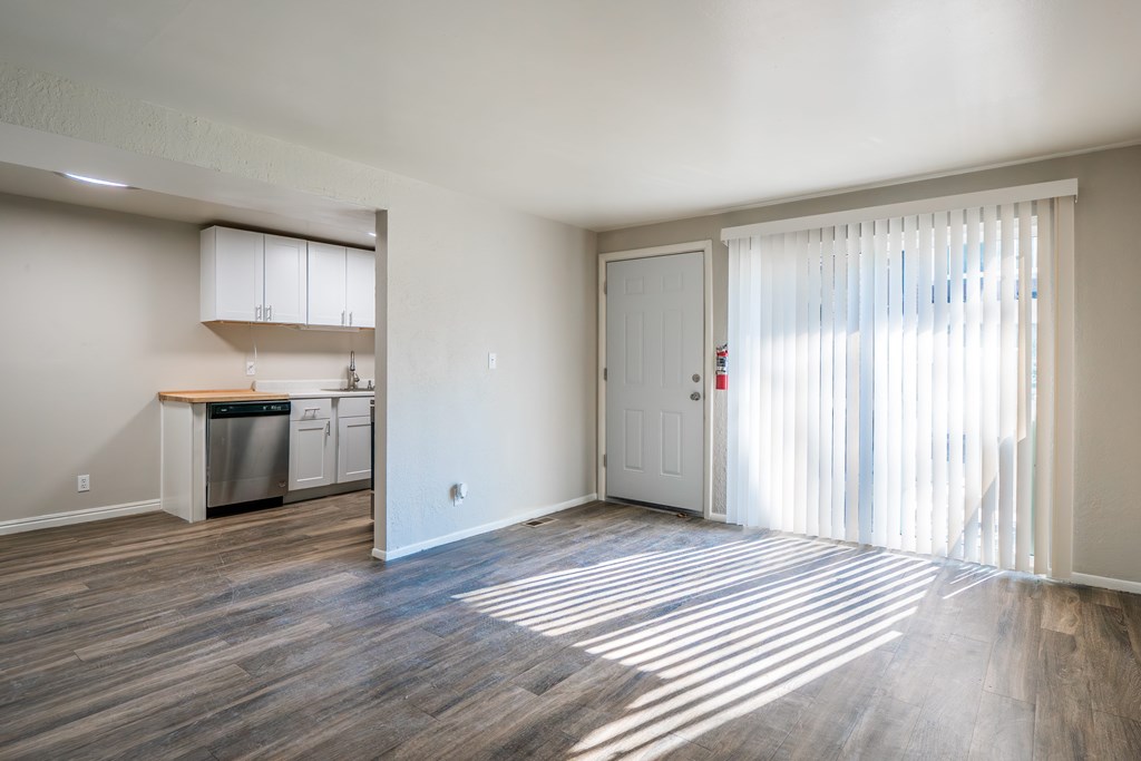 A kitchen with a dishwasher and a sink is visible through a window.