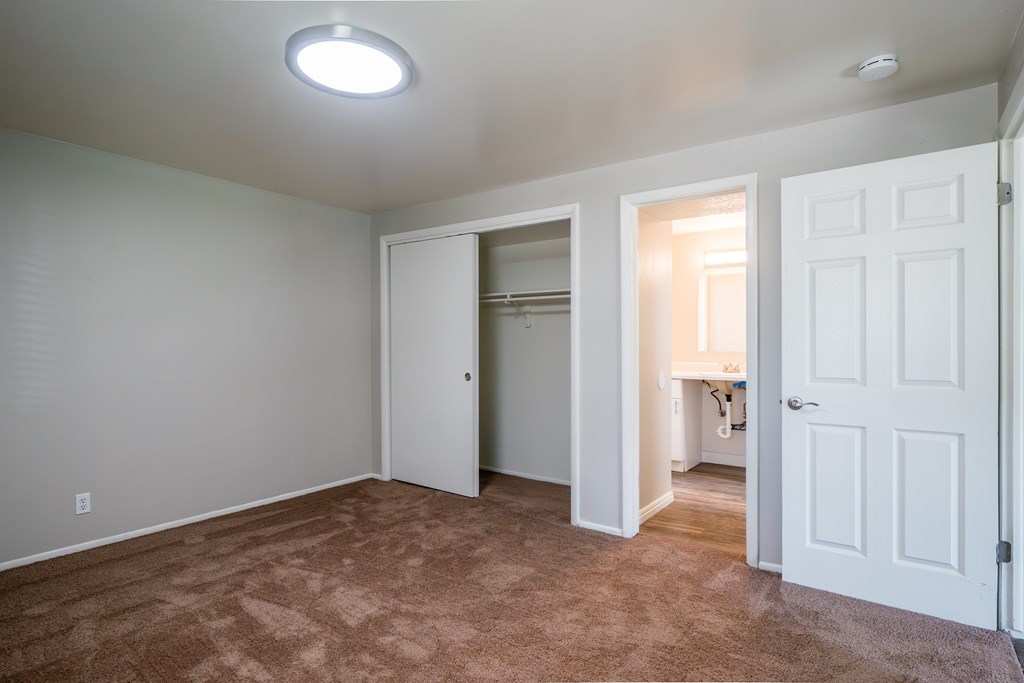 A room with a carpeted floor and a white door.