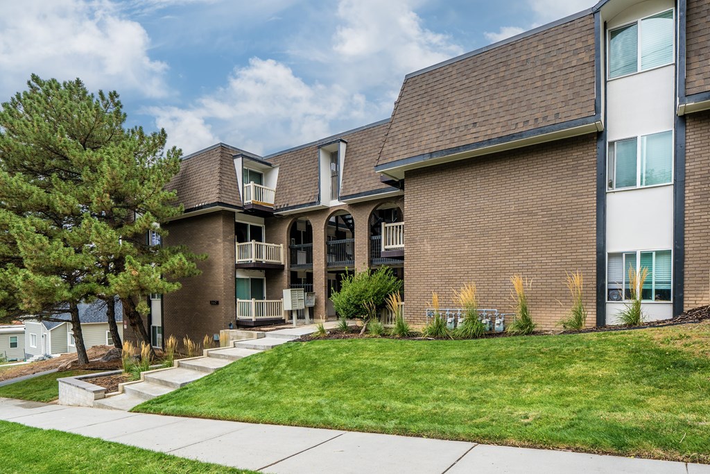 A brown building with a green tree in front.