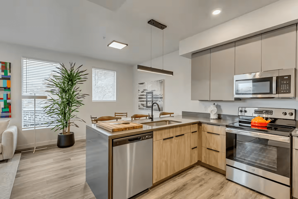 A modern kitchen with stainless steel appliances and wooden cabinets.