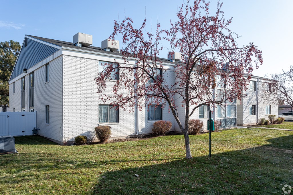 A white house with a tree in front of it.