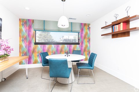 A dining room with a white table and blue chairs.