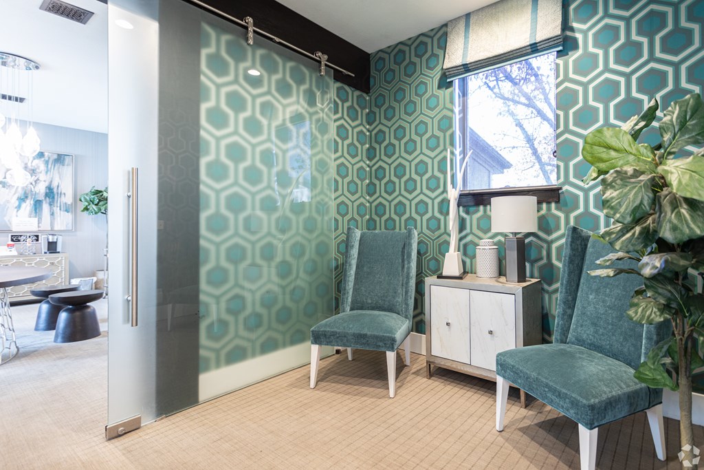 A room with a green patterned wallpaper and a glass door.