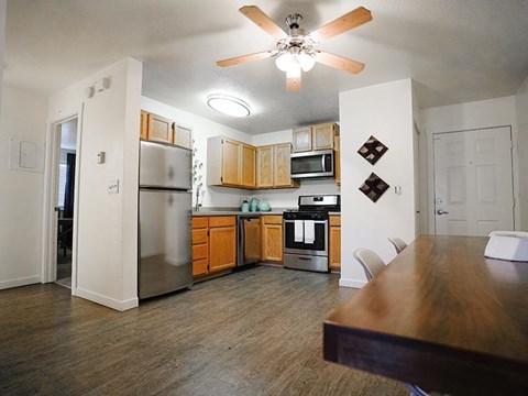 A kitchen with wooden cabinets and a stainless steel refrigerator.