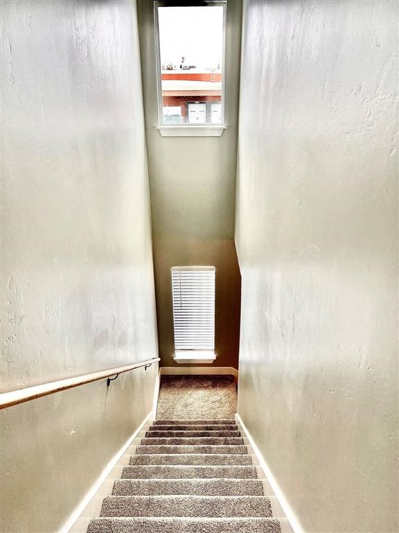 a staircase with a window and a radiator on the wall
