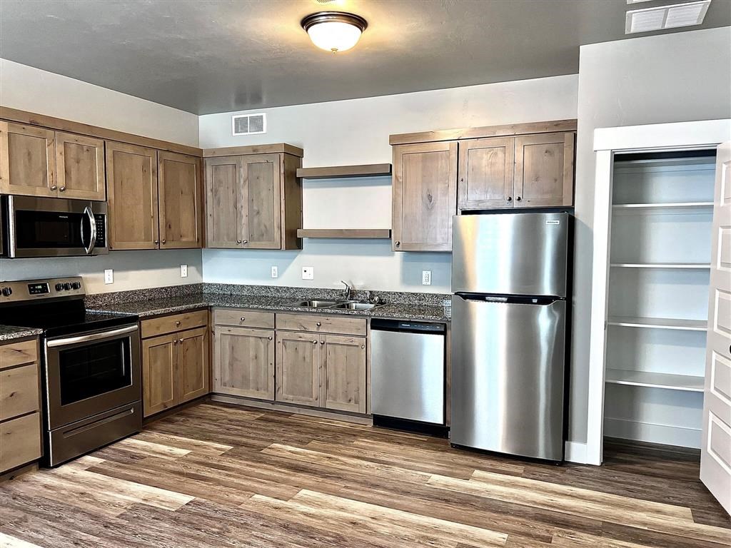 a kitchen with wooden cabinets and a stainless steel refrigerator