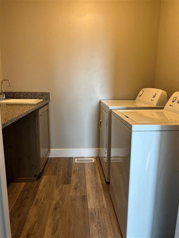 a laundry room with two washers and a sink