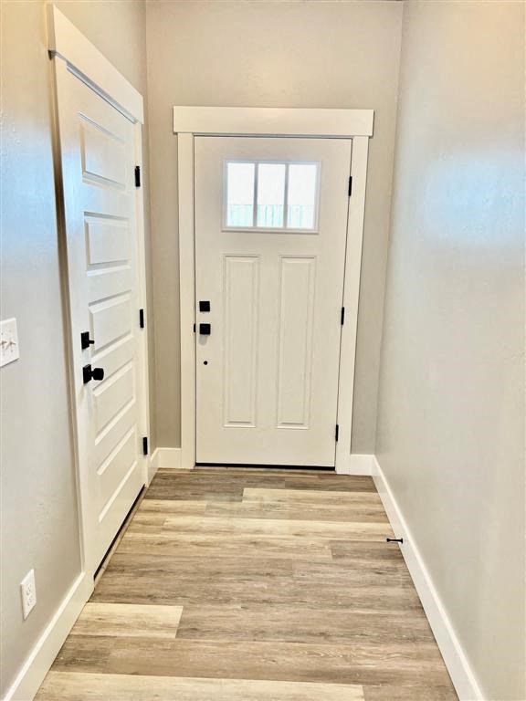 an empty hallway with a white door and a window