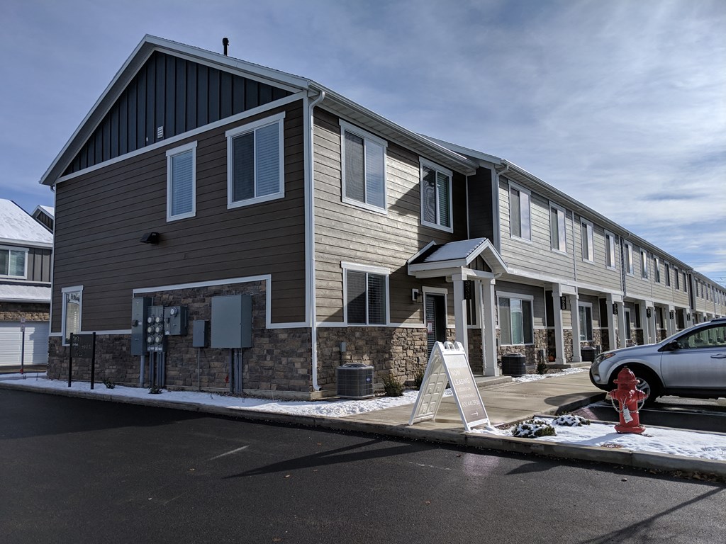 a building with a sign in front of it and a car parked