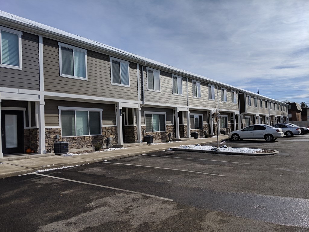 a row of apartment buildings in a parking lot