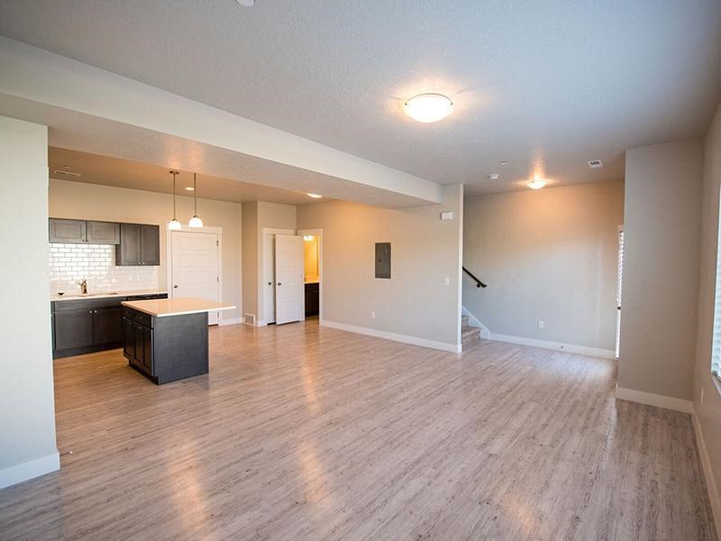an empty living room and kitchen with a wood floor