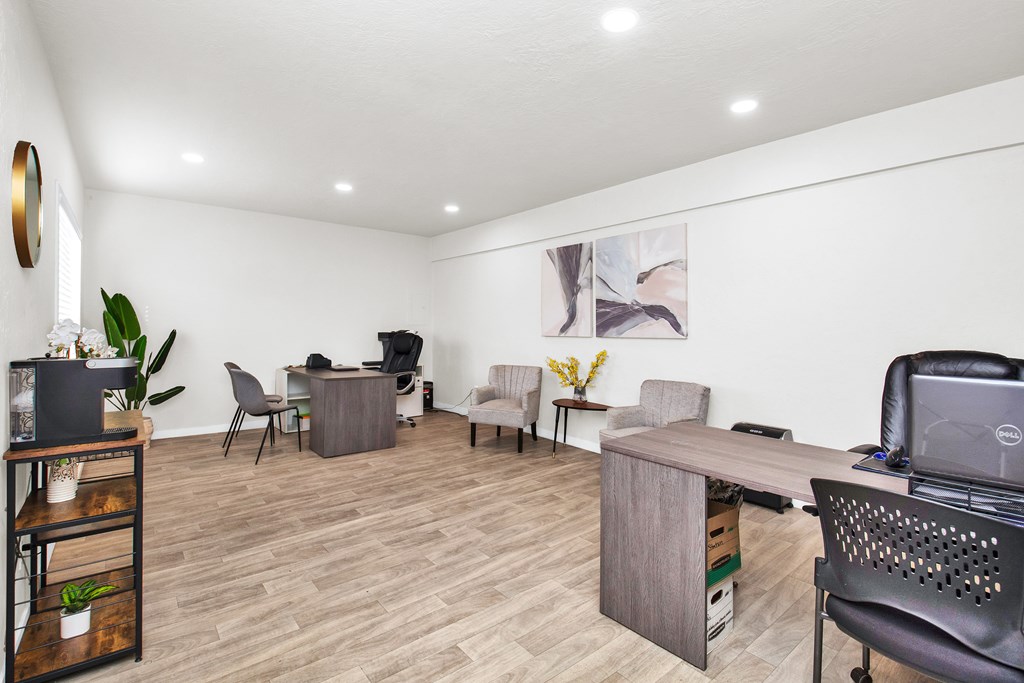 A room with a desk and chairs.